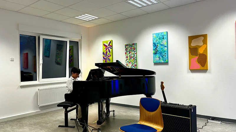 Junge spielt Klavier am Flügel